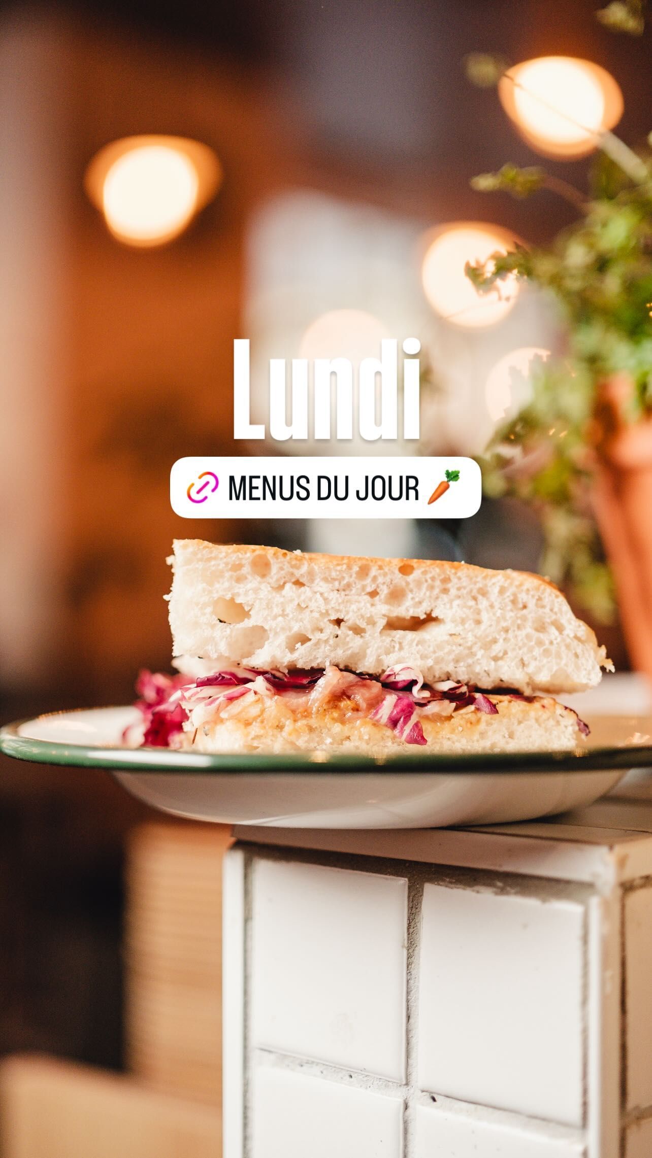 A sandwich with toasted bread and colorful fillings displayed on a plate inside the MÛRE restaurant.