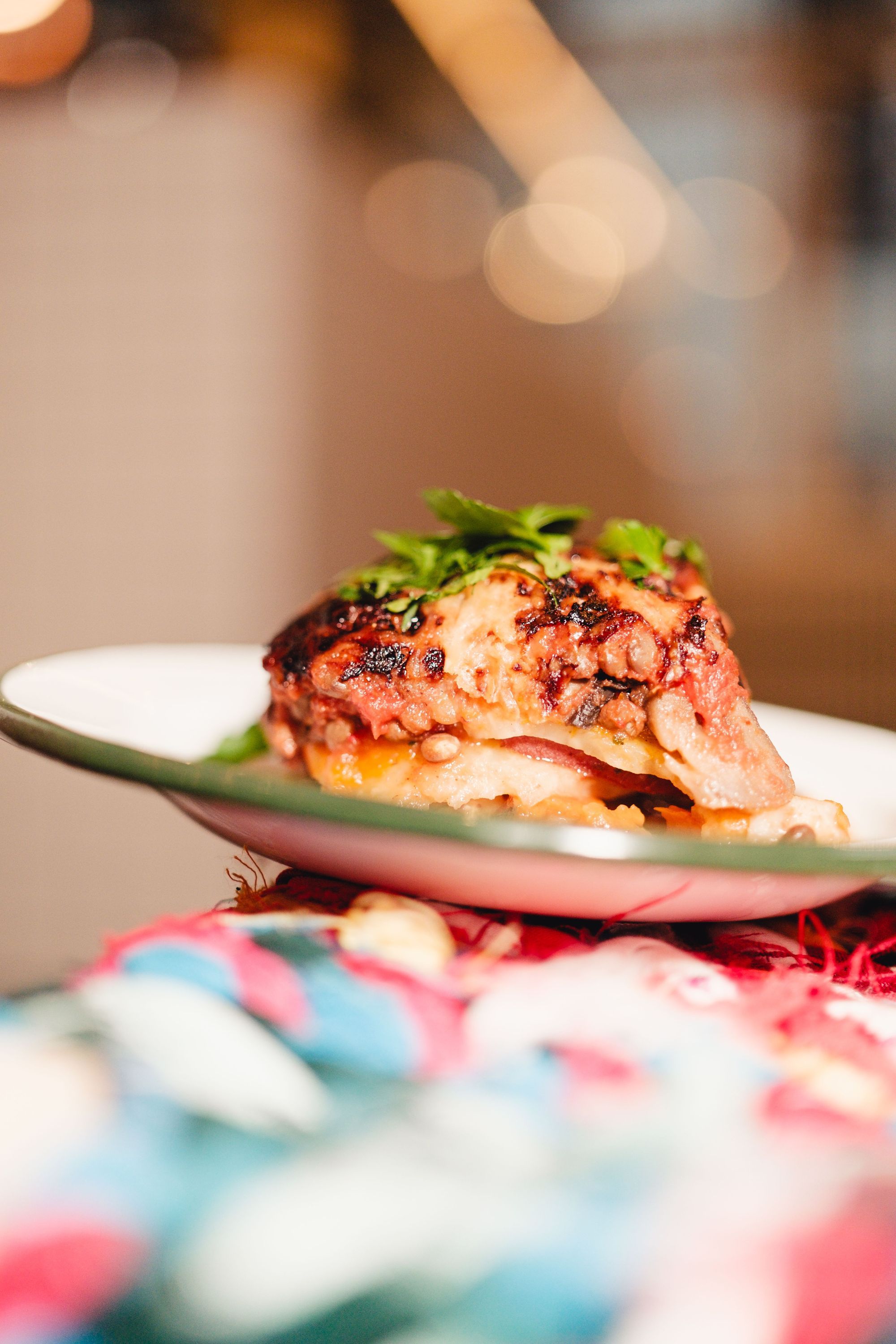 Plat de lasagnes gratinées au fromage, garni de feuilles de basilic, dans un restaurant bio.