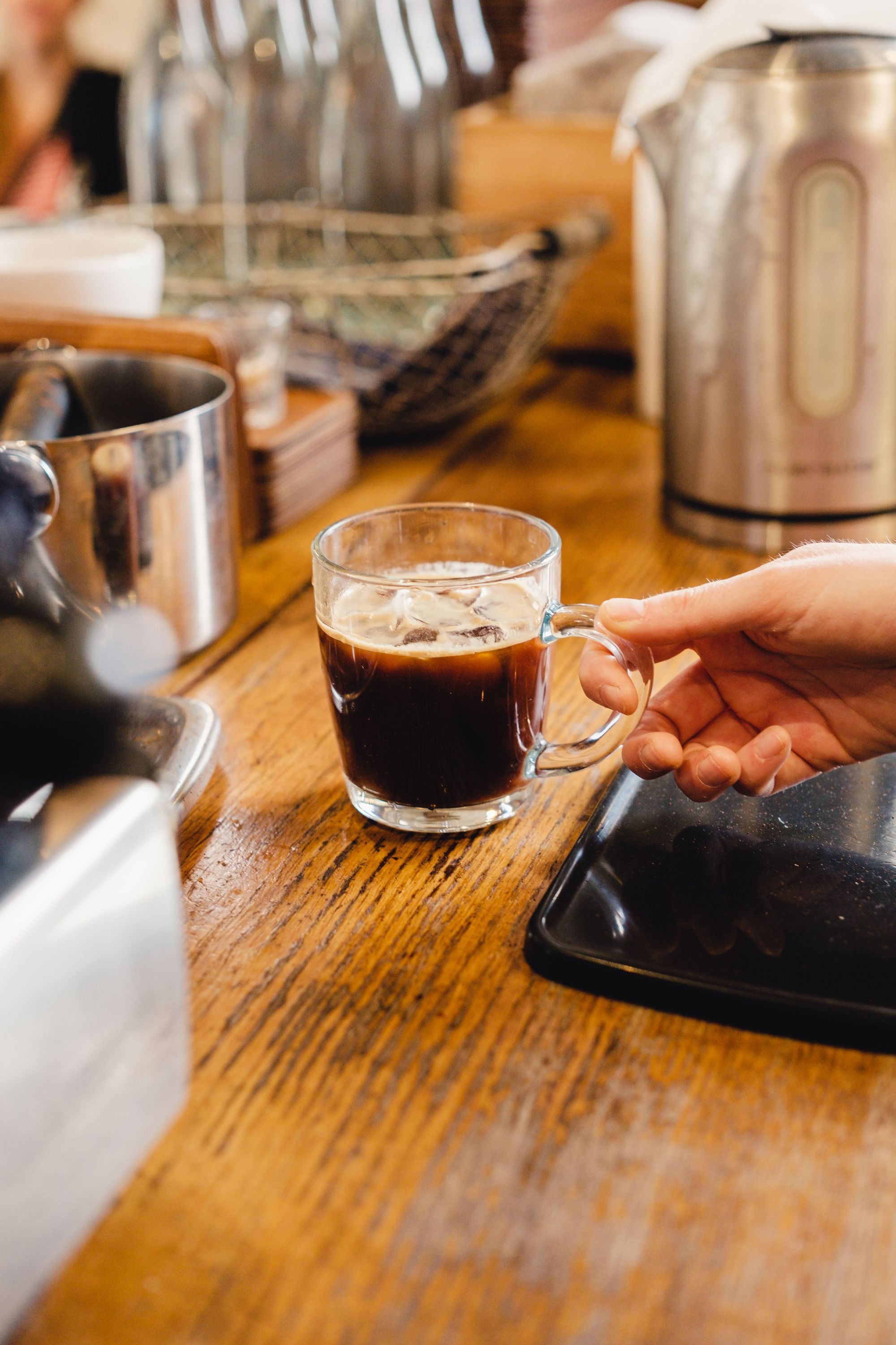 Un verre en verre rempli de café sur un comptoir en bois dans un restaurant bio à Paris.