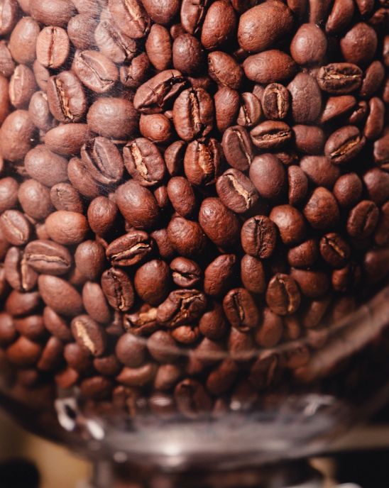 Close-up view of roasted coffee beans tightly packed, showcasing their rich brown color and texture.