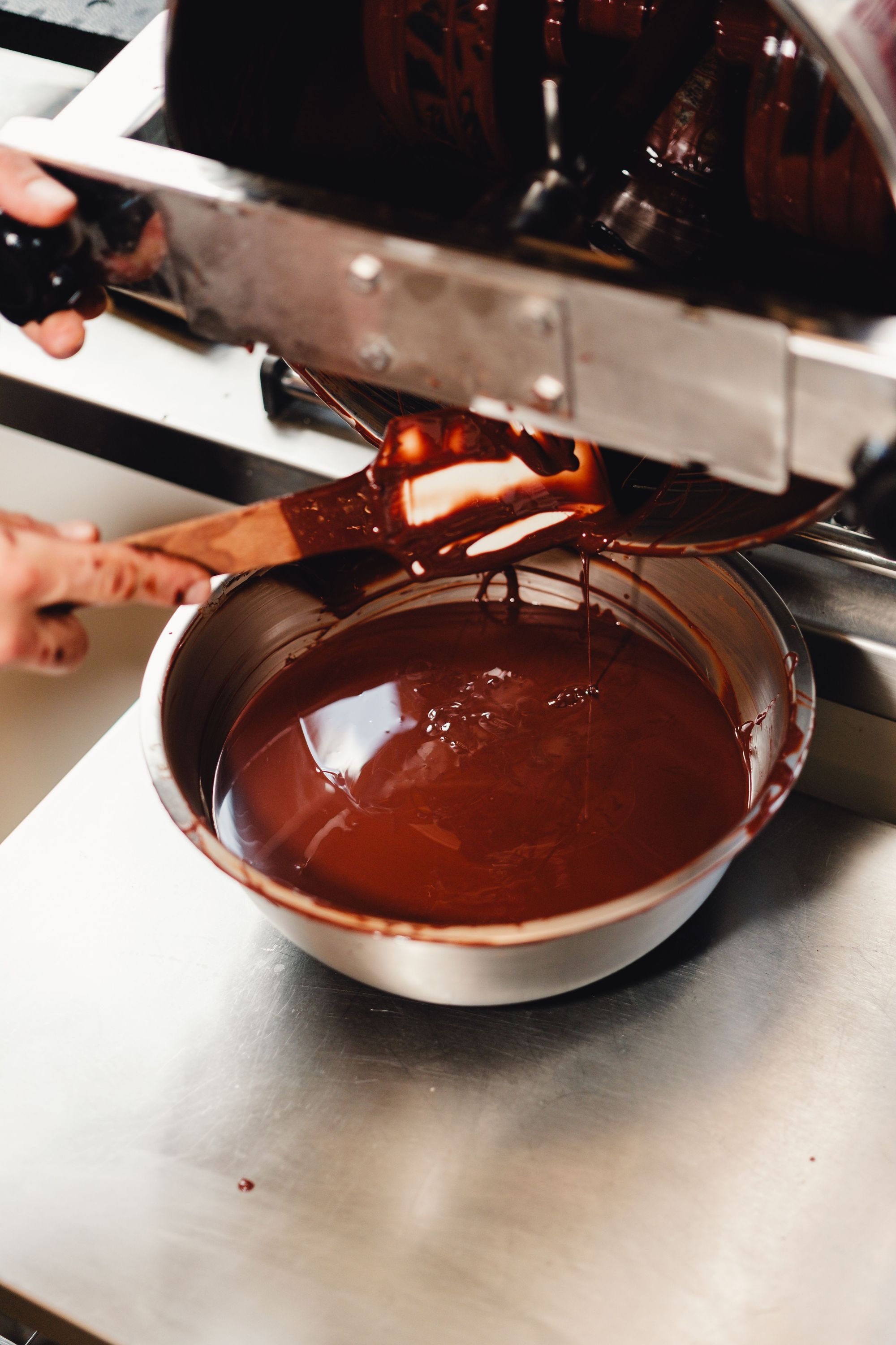 Chocolat fondu versé dans un bol en acier inoxydable dans un restaurant bio à Paris.