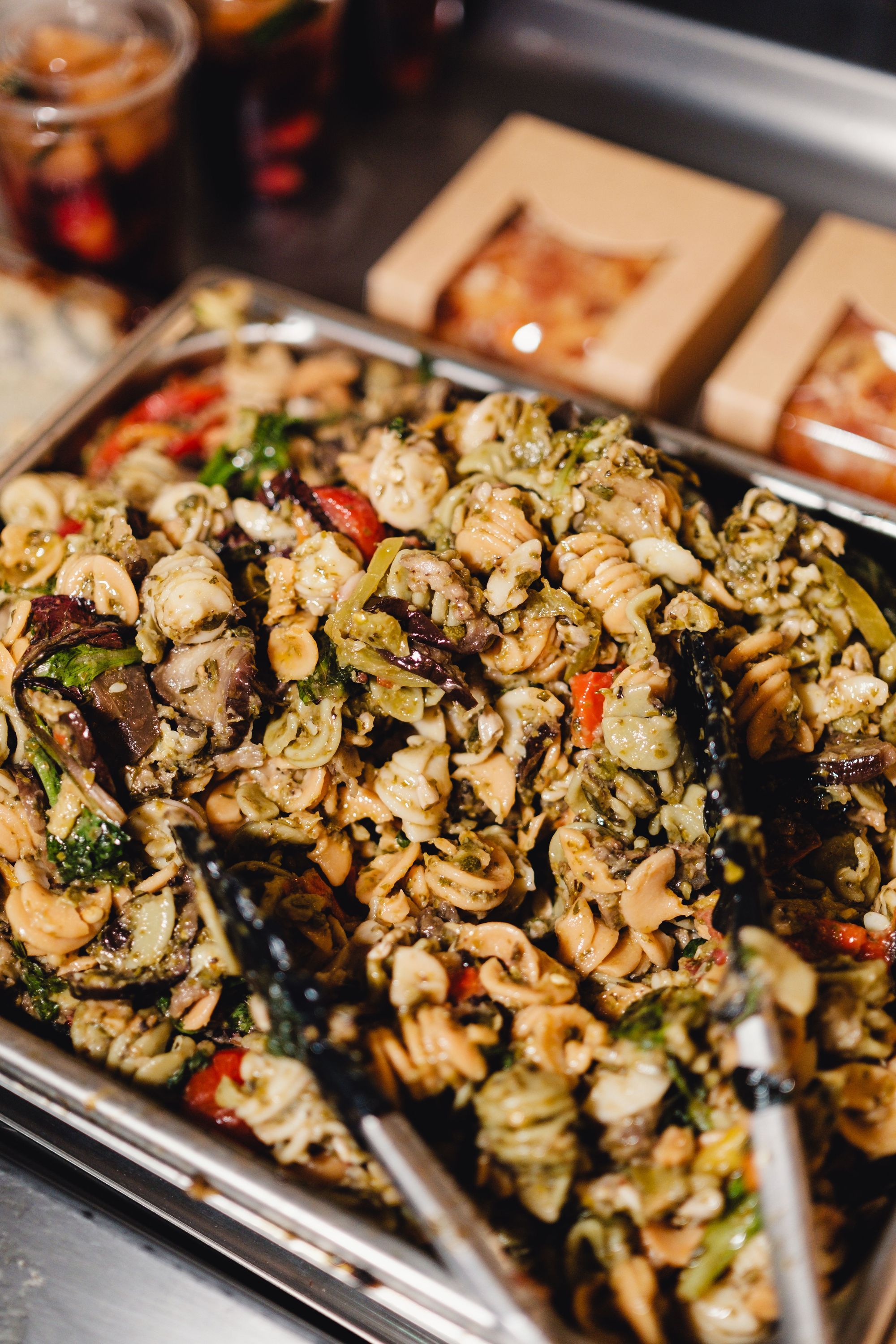 Plat de pâtes végétariennes mélangées avec légumes et herbes, prêt à être servi au buffet du restaurant MURE épicerie.